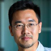 Professional headshot of Dr. Marcus Chen, a friendly and wise male gastroenterologist in his 50s, with a thoughtful demeanor, against a professional clinic background.